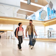 Man and child walking through airport 