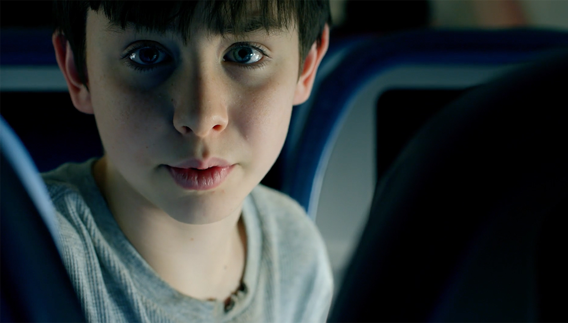 A young boy in a darkly lit space